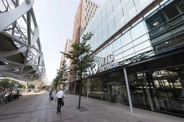 Ingang van WTC The Hague aan de Prinses Beatrixlaan met moderne architectuur en wandelende voetgangers.